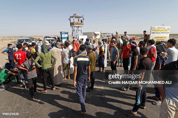 Protesters block the road as they demonstrate against unemployment in front of oil fields in al-Qurnah, some 100 kilometers north of Basra, southern...