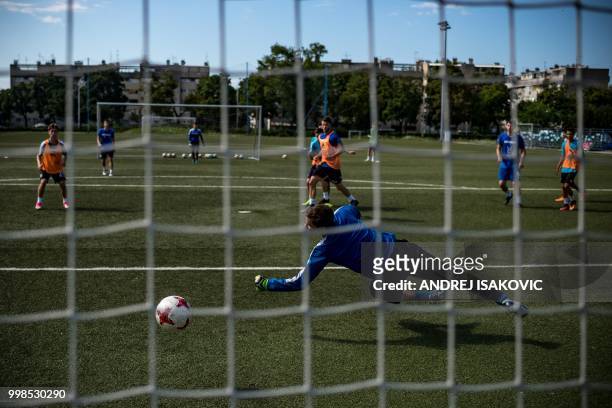 Young Dinamo Zagreb footbal club's goalkeeper tries to catch the ball as team players take part in a training session in Zagreb, on July 14, 2018. -...