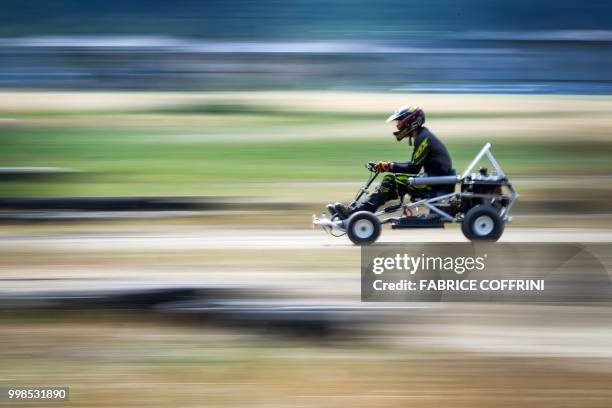 Participant rides a lawn-mover during the 5th edition of the motorised lawn-mower race in Dorenaz, western Switzerland, on July 14, 2018. - 23 teams...