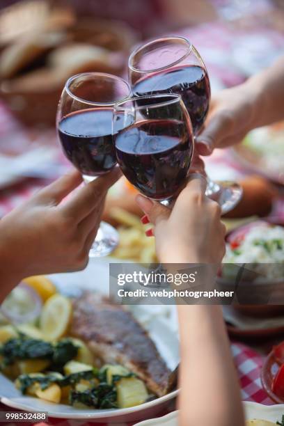 close-up of red wine toast - glass half full party stock pictures, royalty-free photos & images