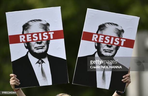Protestor holds placards prior to the Scotland United Against Trump march through the streets of Edinburgh, Scotland on July 14 on the third day of...