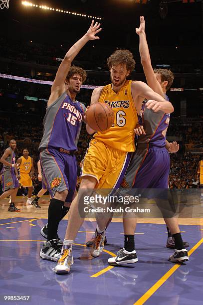 Pau Gasol of the Los Angeles Lakers handles the ball between Robin Lopez and Goran Dragic of the Phoenix Suns in Game One of the Western Conference...