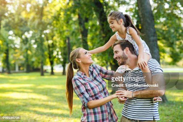 giovane famiglia amorevole che si diverte nel parco - emir memedovski foto e immagini stock