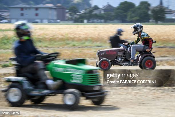 Team members ride their lawn-mowers as they take part in the 5th edition of the motorised lawn mower race on July 14, 2018 in Dorenaz, western...