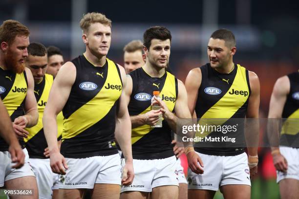 Trent Cotchin of the Tigers and team mates look dejected as they leave the pitch during the round 17 AFL match between the Greater Western Sydney...