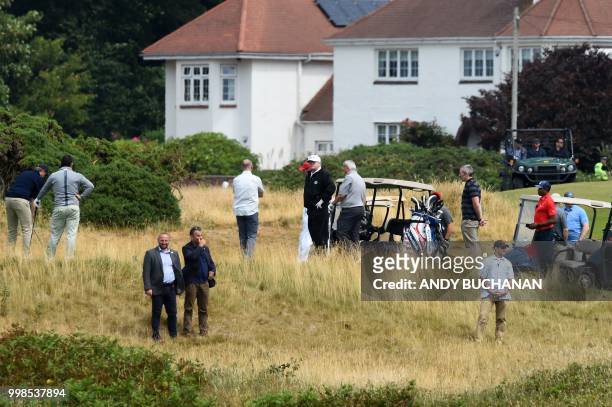 President Donald Trump stands on the first green as he plays a round of golf on the Ailsa course at Trump Turnberry, the luxury golf resort of US...