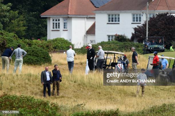 President Donald Trump stands on the first green as he plays a round of golf on the Ailsa course at Trump Turnberry, the luxury golf resort of US...