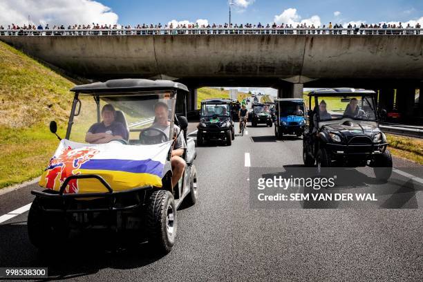 Sustainably fuelled vehicles pass under an aqueduct as they travel on the N31 highway near Leeuwarden on July 14 which has been specially closed for...