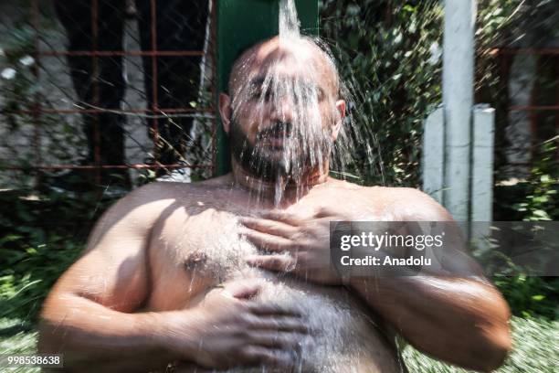 Wrestler cools off under a fountain after competing on the second day of the 657th annual Kirkpinar Oil Wrestling Festival in Sarayici near Edirne,...