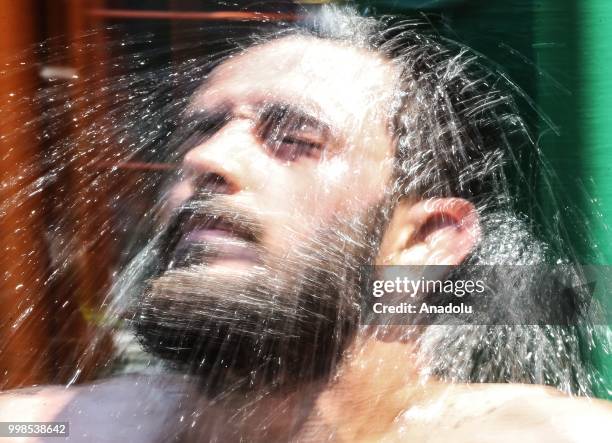 Wrestler cools off under a fountain after competing on the second day of the 657th annual Kirkpinar Oil Wrestling Festival in Sarayici near Edirne,...