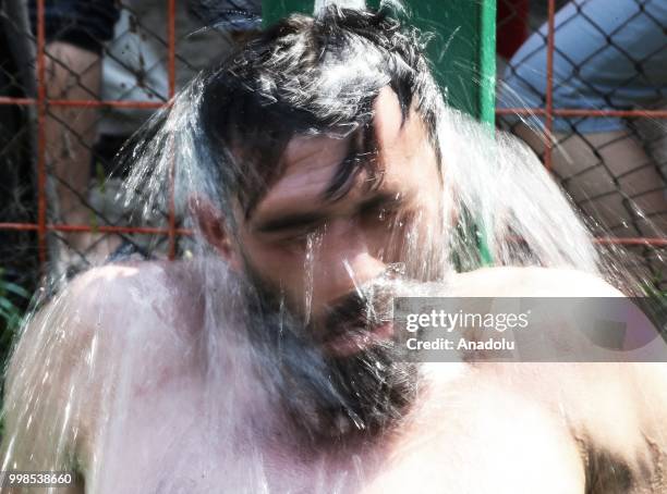 Wrestler cools off under a fountain after competing on the second day of the 657th annual Kirkpinar Oil Wrestling Festival in Sarayici near Edirne,...