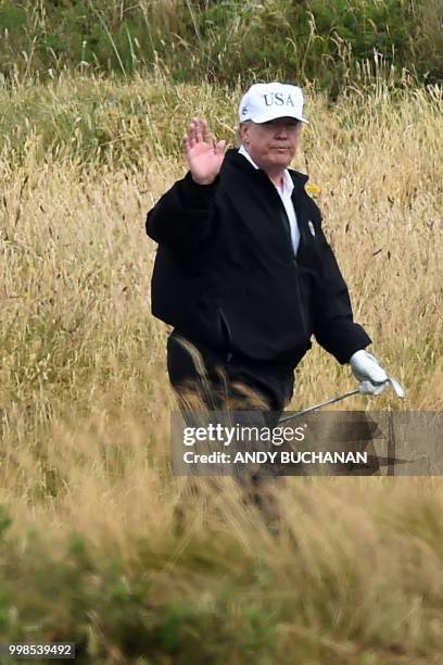 President Donald Trump waves as he walks during a round of golf on the Ailsa course at Trump Turnberry, the luxury golf resort of US President Donald...