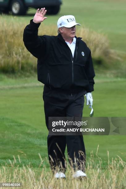 President Donald Trump gestures as he walks during a round of golf on the Ailsa course at Trump Turnberry, the luxury golf resort of US President...