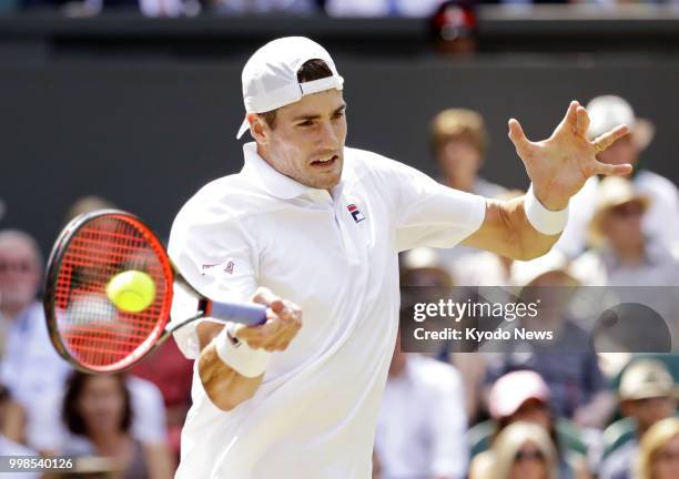 John Isner of the United States hits a forehand against Kevin Anderson of South Africa during a Wimbledon semifinal match in London on July 13, 2018....