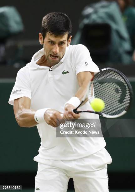 Novak Djokovic of Serbia hits a backhand against Rafael Nadal of Spain during a Wimbledon semifinal match in London on July 13, 2018. The match was...