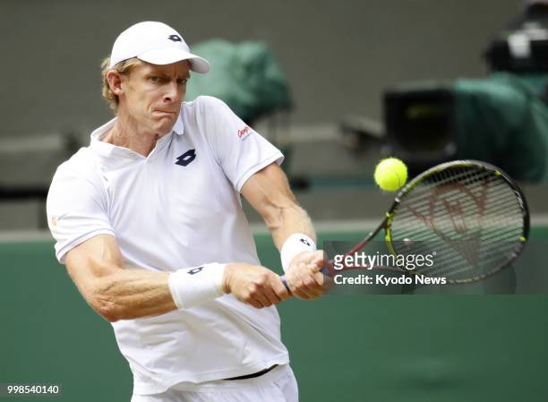 Kevin Anderson of South Africa hits a backhand against John Isner of the United States during a Wimbledon semifinal match in London on July 13, 2018....
