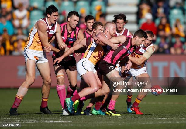 Luke Breust of the Hawks is tackled by Nick Robertson ad Mitch Robinson of the Lions during the 2018 AFL round 17 match between the Hawthorn Hawks...