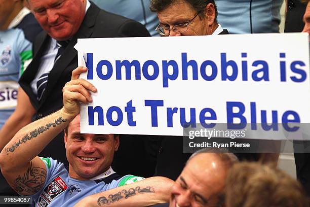 Anthony Watmough of the NSW Blues picks up a sponsors sign during the NSW Blues Media Call and team photo session at ANZ Stadium on May 18, 2010 in...