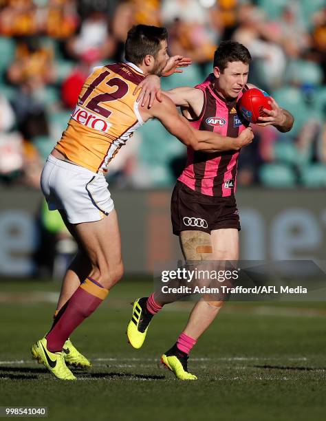 Liam Shiels of the Hawks is tackled by Stefan Martin of the Lions during the 2018 AFL round 17 match between the Hawthorn Hawks and the Brisbane...