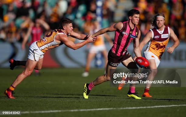 Jaeger O'Meara of the Hawks is tackled by Dayne Zorko of the Lions during the 2018 AFL round 17 match between the Hawthorn Hawks and the Brisbane...