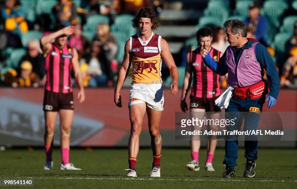 Jarrod Berry of the Lions leaves the field with doctors after a heavy knock during the 2018 AFL round 17 match between the Hawthorn Hawks and the...