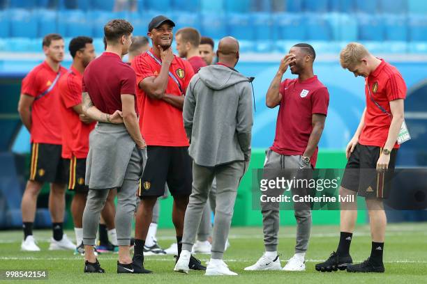 Vincent Kompany and Kevin De Bruyne of Belgium talk to John Stones, Raheem Sterling and Fabian Delph of England during a pitch inspection prior to...