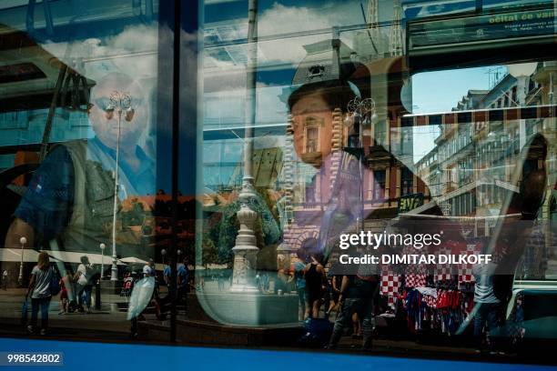 People on a tram look at a kiosk where Croatian national team jerseys are seen, in the downtown of Zagreb on July 14 ahead of the 2018 Russia World...