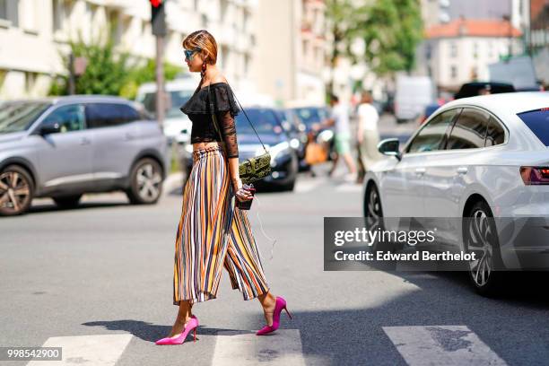 Guest wears a black lace mesh top, striped colored cropped large pants, pink shoes , outside Acne Studios, during Paris Fashion Week - Womenswear...