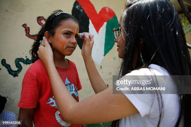 Palestinian girl from the Bedouin village of Khan al-Ahmar in the occupied West Bank, has her face painted during the Palestinian Prime Minister's...
