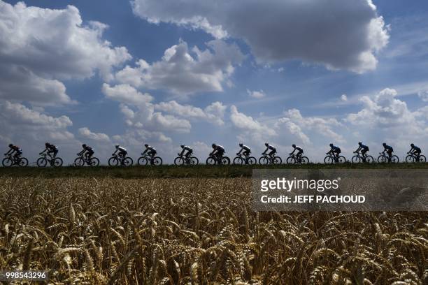 The pack rides past wheat fields during the eighth stage of the 105th edition of the Tour de France cycling race between Dreux and Amiens, northern...
