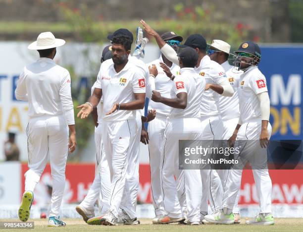 Sri Lankan cricketer Dilruwan Perera celebrates with team members during the 3rd day's play in the first Test cricket match between Sri Lanka and...