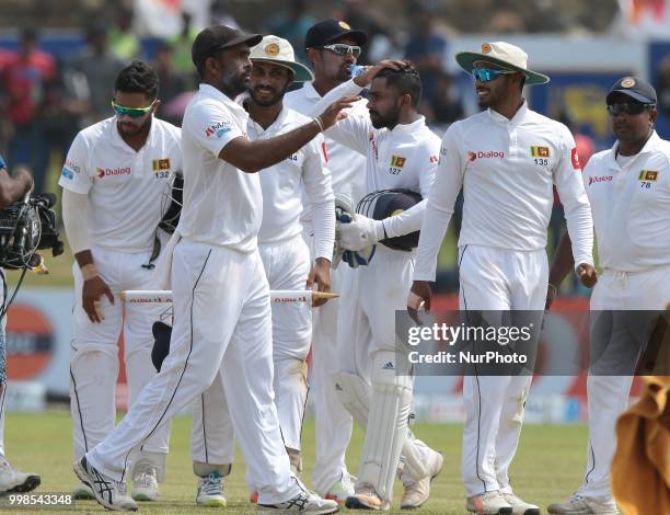 Sri Lankan cricketer Dilruwan Perera celebrates with his team mates during the 3rd day's play in the first Test cricket match between Sri Lanka and...
