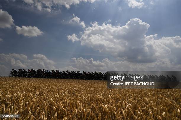 The pack rides past wheat fields during the eighth stage of the 105th edition of the Tour de France cycling race between Dreux and Amiens, northern...