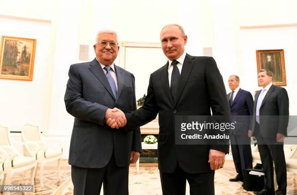 Palestinian President, Mahmoud Abbas and President of Russia, Vladimir Putin shake hands as they pose for a photo during their meeting at the Kremlin...