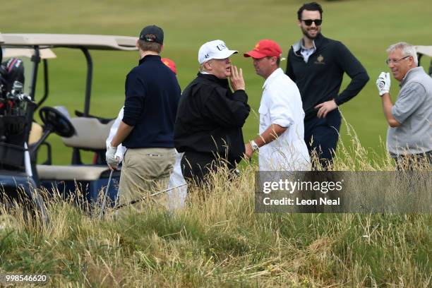 President Donald Trump talks as his son Eric Trump waits as they play golf at Trump Turnberry Luxury Collection Resort during the President's first...