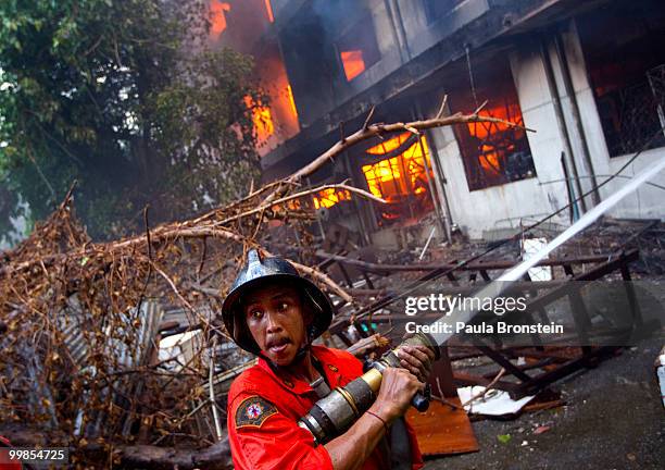 Firefighters work to control a blaze set by Thai anti-government red shirt protesters on May 18, 2010 in Bangkok, Thailand. Protesters have clashed...