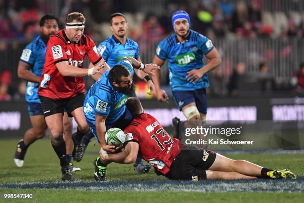 Ross Wright of the Blues is tackled by Jack Goodhue of the Crusaders during the round 19 Super Rugby match between the Crusaders and the Blues at AMI...