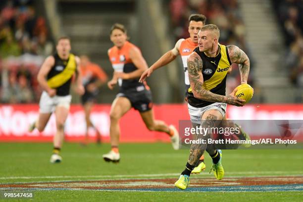 Dustin Martin of the Tigers runs with the ball during the round 17 AFL match between the Greater Western Sydney Giants and the Richmond Tigers at...