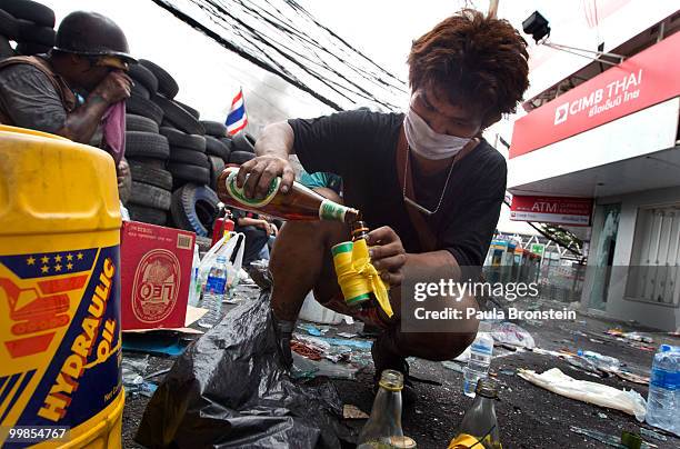 Thai anti-government red shirt protester fills a molotov cocktail on May 18, 2010 in Bangkok, Thailand. Protesters have clashed with military forces...