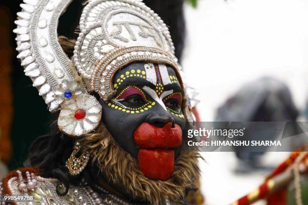 An Indian Hindu devotee dressed as lord Hanuman poses for a picture during the annual Jagannath Rath Yatra festival in Ajmer, in the Indian state of...