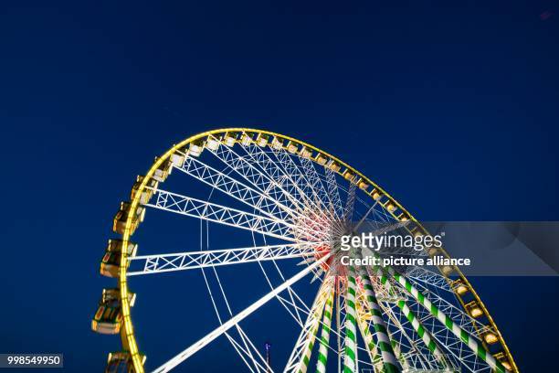 July 2018, Germany, Duesseldorf: A Ferris wheel standing at the Rheinkirmes in Duesseldorf. The Rheinkirmes in Duesseldorf is taking place from 13...