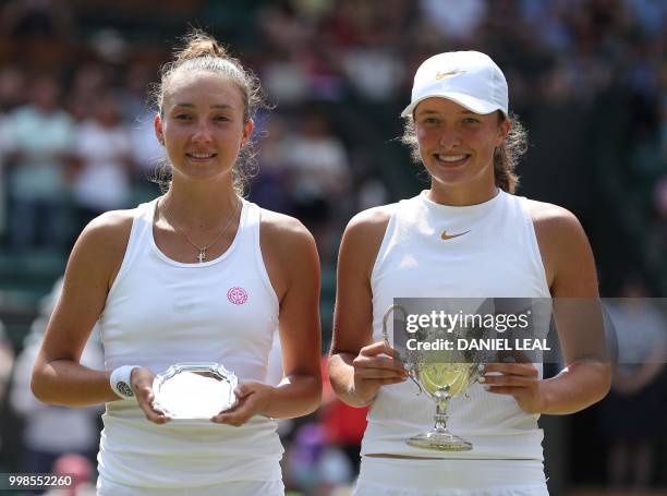 Poland's Iga Swiatek and Switzerland's Leonie Kung pose with their trophies following their girls' singles final match on the twelfth day of the 2018...