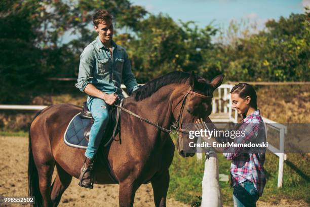 giovane coppia sorridente con cavallo all'aperto - emir memedovski foto e immagini stock