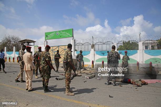 Soldiers lie on the road after a double car bomb blast followed by a gun battle at a security checkpoint near the presidential palace in Mogadishu,...