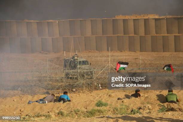 Palestinian youths seen in front of the separation fence east of al-Bureij camp. Clashes between Palestinian citizens and the Israeli forces on the...