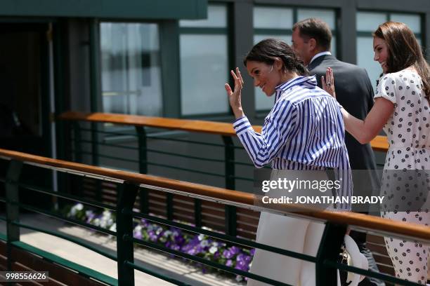 Britain's Catherine, Duchess of Cambridge and Britain's Meghan, Duchess of Sussex way as they arrive to watch the women's final match on the twelfth...