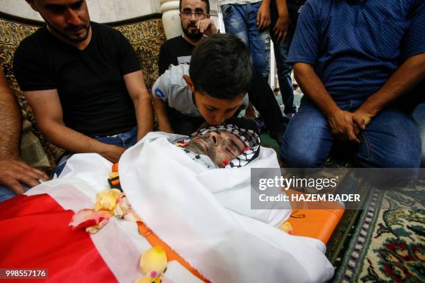 Graphic content / The son of killed Palestinian Rami Sabarneh kisses his dead father's head during his funeral in the village of Beit Ummar, north of...