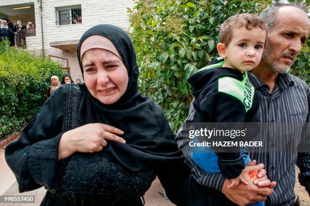 Graphic content / The sister of killed Palestinian Rami Sabarneh mourns as she walks uotside their home during his funeral in the village of Beit...