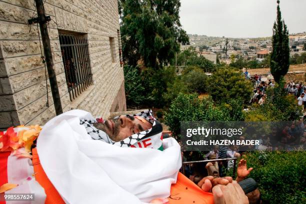 Graphic content / Mourners carry the body of killed Palestinian Rami Sabarneh during his funeral in the village of Beit Ummar, north of Hebron in the...