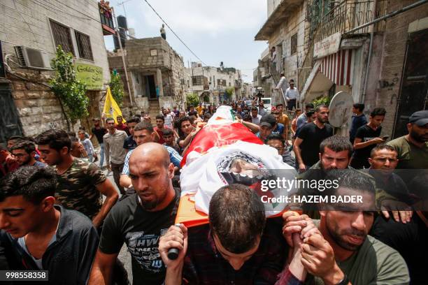 Mourners carry the body of killed Palestinian Rami Sabarneh during his funeral in the village of Beit Ummar, north of Hebron in the occupied West...